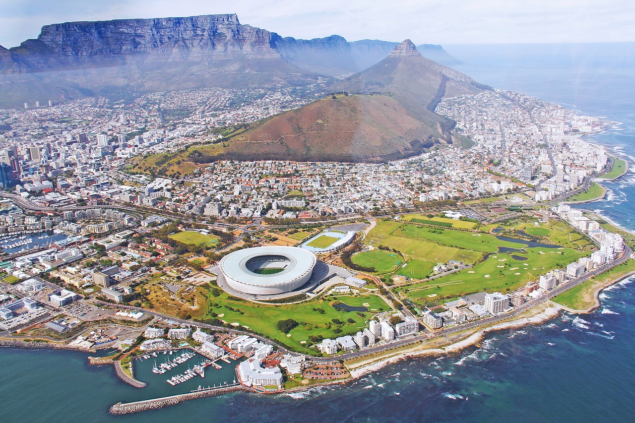 cape town south africa Aerial view of Cape Town, featuring a stadium, coastal area, and Table Mountain in the background.